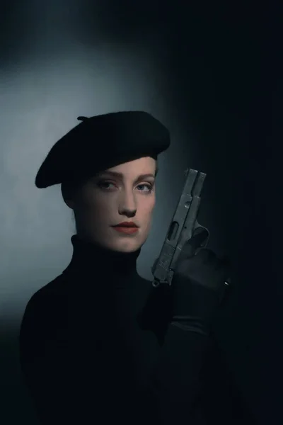 Retro 1940s woman with beret holding pistol. — Stock Photo, Image