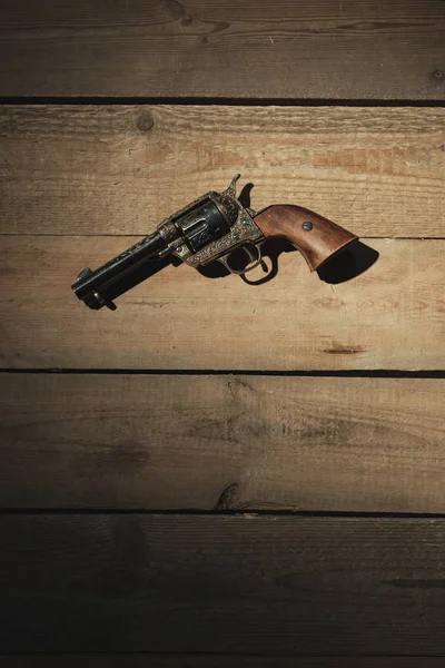 Pistol revolver bersejarah di lantai kayu tua . — Stok Foto