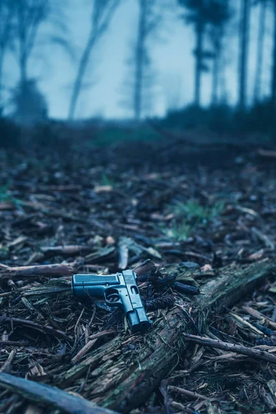 Pistola perdida no chão na floresta nebulosa de inverno . — Fotografia de Stock