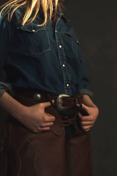 Cowgirl loira com chaps de couro marrom e camisa jeans . — Fotografia de Stock