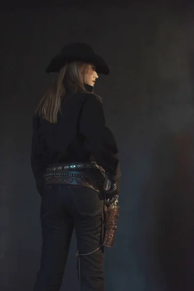 Blonde cowgirl in black hat wearing holster. — Stock Photo, Image