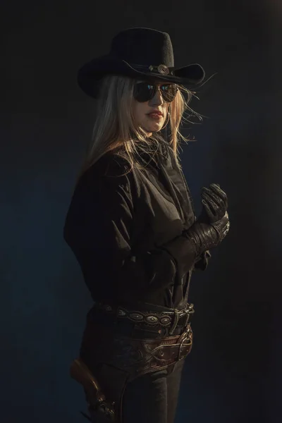 Cowgirl blonde en chapeau noir portant des lunettes de soleil sombres . — Photo