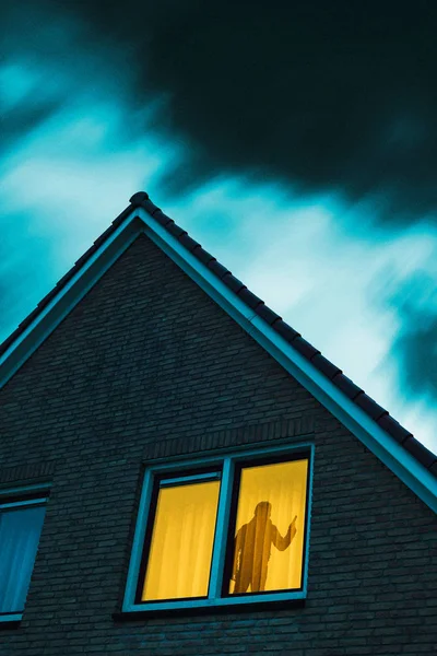Intruso con pistola en casa misteriosa con ventana iluminada und — Foto de Stock