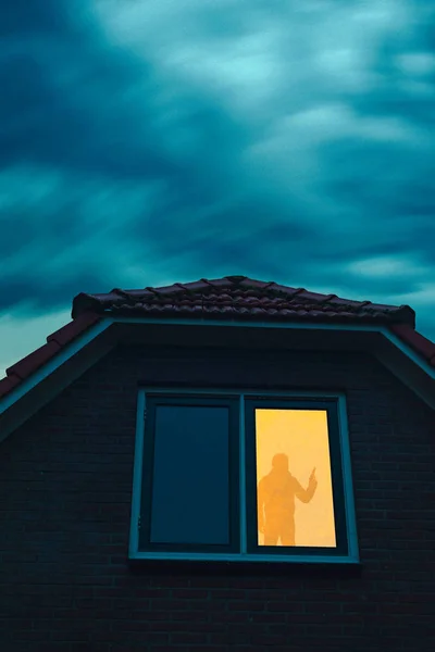 Burglar with handgun in ominous house with illuminated window un — Stock Photo, Image