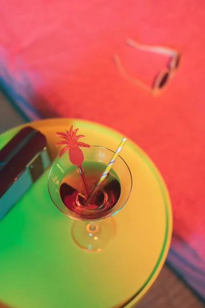 Sarı masa, kokteyl içeceği ve güneş ışığının yanında taşınabilir radyo. — Stok fotoğraf