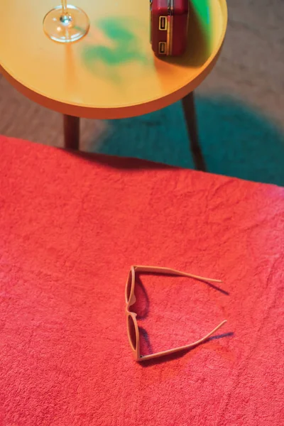 Lunettes de soleil sur chaise longue avec table jaune et cocktail et po — Photo