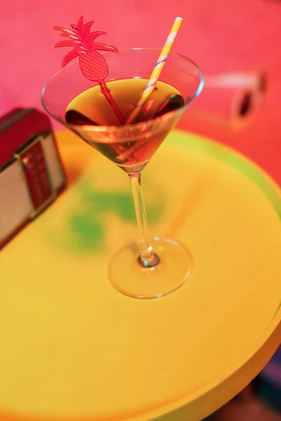 在阳光旁边的黄色桌子上的鸡尾酒饮料和老式收音机 — 图库照片