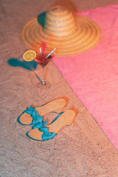 Chaussures vintage pour dames et verre à cocktail dans le sable à côté du remorquage rose — Photo