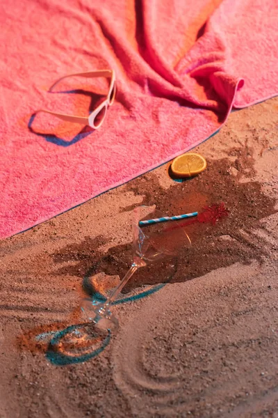 Padlý koktejl sklo a vinobraní dámské boty vedle růžového ručníku — Stock fotografie