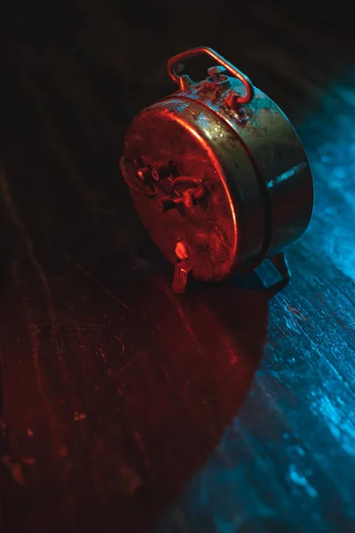 Dusty old alarm clock on worn wooden table at night. Backside. — Stock Photo, Image