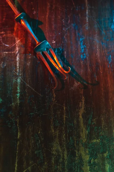 Old bent meat fork on scratched wooden table. — Stock Photo, Image