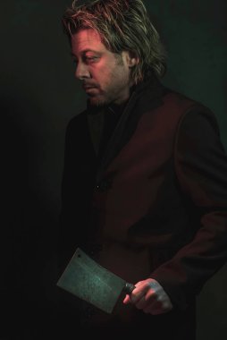 Threatening man with cleaver in hand illuminated by red and blue