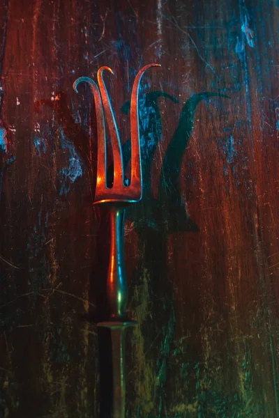 Vecchia forchetta di carne piegata su tavolo di legno graffiato . — Foto Stock