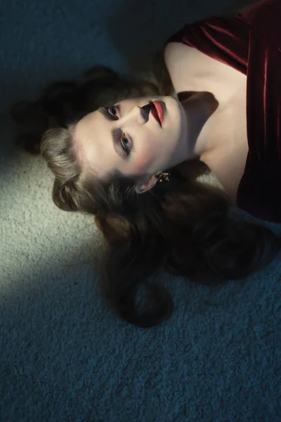 死了的女人 金发碧眼 穿着红衣服 躺在白地毯上 — 图库照片
