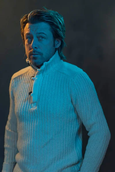 Man Met Witte Wollen Trui Verlicht Door Geel Blauw Licht — Stockfoto