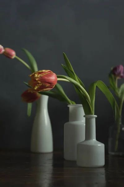 木製のテーブルの上に赤いチューリップの白い花瓶 — ストック写真