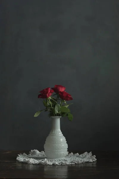 Trzy Czerwone Róże Białym Wazonie Drewnianym Stole Koronki Tkaniny — Zdjęcie stockowe