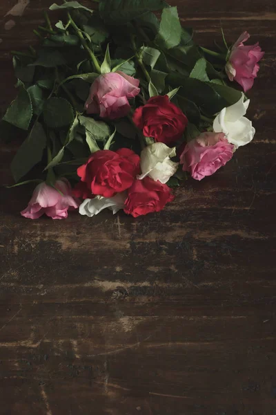 放在木制桌子上的红玫瑰 粉红玫瑰和白玫瑰 — 图库照片