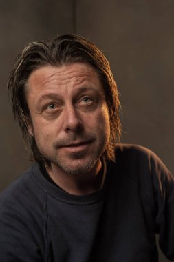 Gülümseyen bir adamın stüdyo portresi.