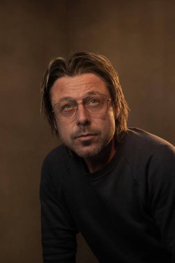 Retro gözlük takan bir adamın stüdyo portresi.