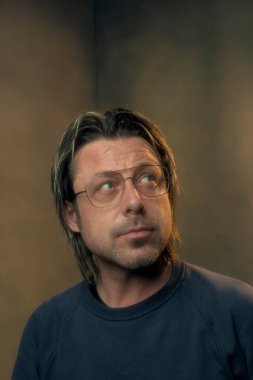 Retro gözlük takan bir adamın stüdyo portresi.