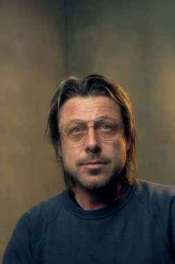 Retro gözlük takan bir adamın stüdyo portresi.