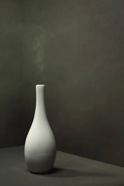灰色の空の空間で煙と白い陶器の花瓶 — ストック写真