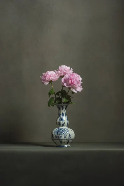 Roze Pioenrozen Een Delft Blauwe Vaas Een Tafel Een Grijze — Stockfoto
