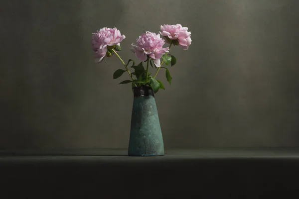 在一间灰色房间的桌子上 一只老式陶器花瓶里的粉色牡丹 — 图库照片