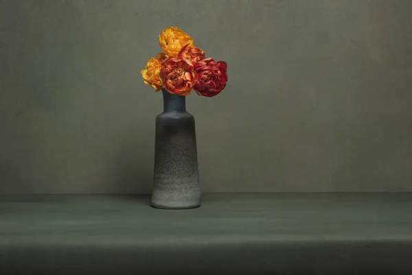 グレーの部屋に赤とオレンジの牡丹のチューリップとヴィンテージ花瓶 — ストック写真