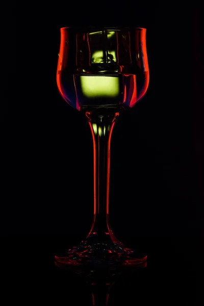 Silueta sklenice s nápojem v baru na černém pozadí — Stock fotografie