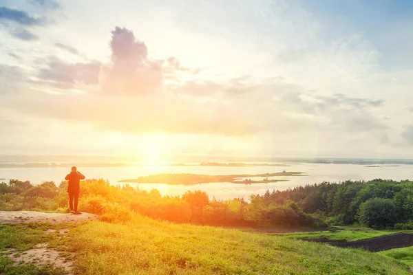 Hiker is taking photo by smart phone on the peak of mountain at sunrise. — Stock Photo, Image