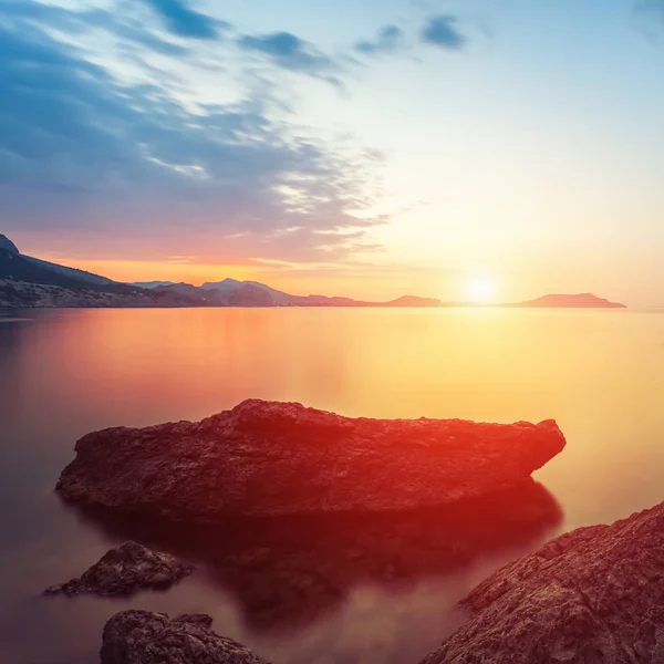 Prachtig zeegezicht. zee en rots op de zonsondergang. natuur samenstelling. — Stockfoto