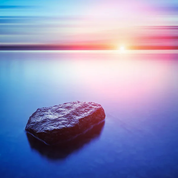 Prachtig zeegezicht. Zee en rots op de zonsondergang. Samenstelling van de natuur. Lange blootstelling fotografie. — Stockfoto