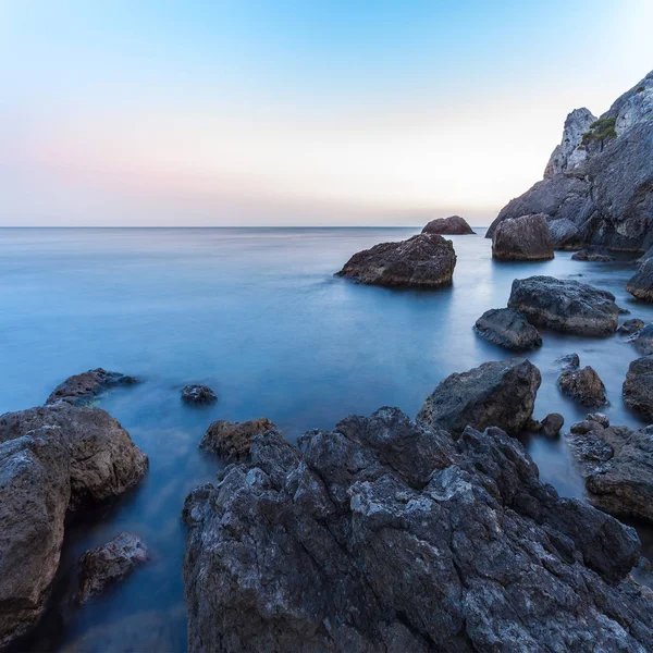 Wunderschöne Meereslandschaft. Meer und Felsen bei Sonnenuntergang. Naturzusammensetzung. Langzeitbelichtungsfotografie. — Stockfoto