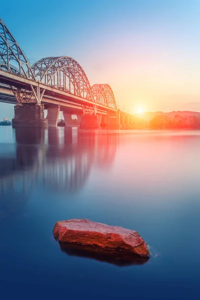 Bil- och järnväg bro i Kiev, huvudstaden i Ukraina. Bron vid solnedgången över floden Dnepr. — Stockfoto