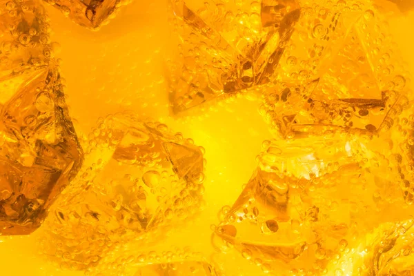 Close-up de cubos de gelo em bebida ou suco de laranja — Fotografia de Stock