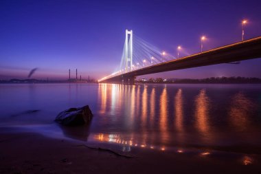 Güney köprüsü, Kiev, Ukrayna. Gün batımında Dinyeper Nehri 'nin karşısındaki köprü.