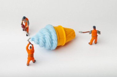 Minyatür insanlar dondurma, yemek pişirme ve dekorasyon konsepti taşıyorlar. Herhangi bir soruna toplu çözüm kavramı. Yakın çekim görünümü.