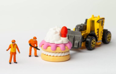 Minyatür insanlar pastayı çilek, yemek pişirme ve dekorasyon konseptiyle taşır. Herhangi bir soruna toplu çözüm kavramı.