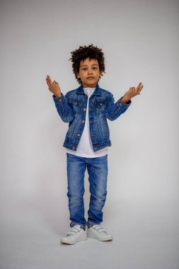 Esmer çocuk kot ve beyaz bir süveterin içinde farklı pozlar farklı duygular farklı arka plan üzerinde gösterir.