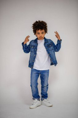 Esmer çocuk kot ve beyaz bir süveterin içinde farklı pozlar farklı duygular farklı arka plan üzerinde gösterir.