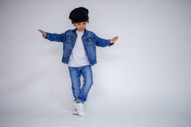 Esmer çocuk kot ve beyaz bir süveterin içinde farklı pozlar farklı duygular farklı arka plan üzerinde gösterir.