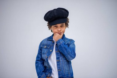 Esmer çocuk kot ve beyaz bir süveterin içinde farklı pozlar farklı duygular farklı arka plan üzerinde gösterir.