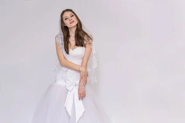 美丽的新娘穿着白色婚纱在不同的姿势白色背景显示不同的情绪 — 图库照片