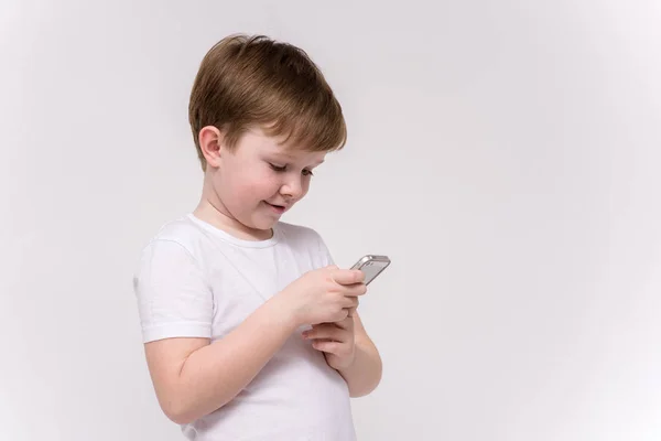 Aranyos Éves Fiú Beszél Telefonon Kattintson Gombok Smartphone Egy Fehér — Stock Fotó