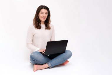 Kız bir dizüstü bilgisayar ile katta oturuyor