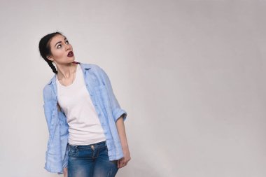 Duygular gösterilen gri arka plan üzerinde güzel bir esmer kız portresi.