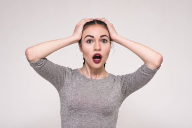 Parlak duygular gösterilen gri arka plan üzerinde güzel bir esmer kız portresi