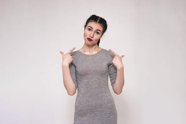 Retrato de una hermosa morena sobre un fondo gris mostrando sus emociones — Foto de Stock